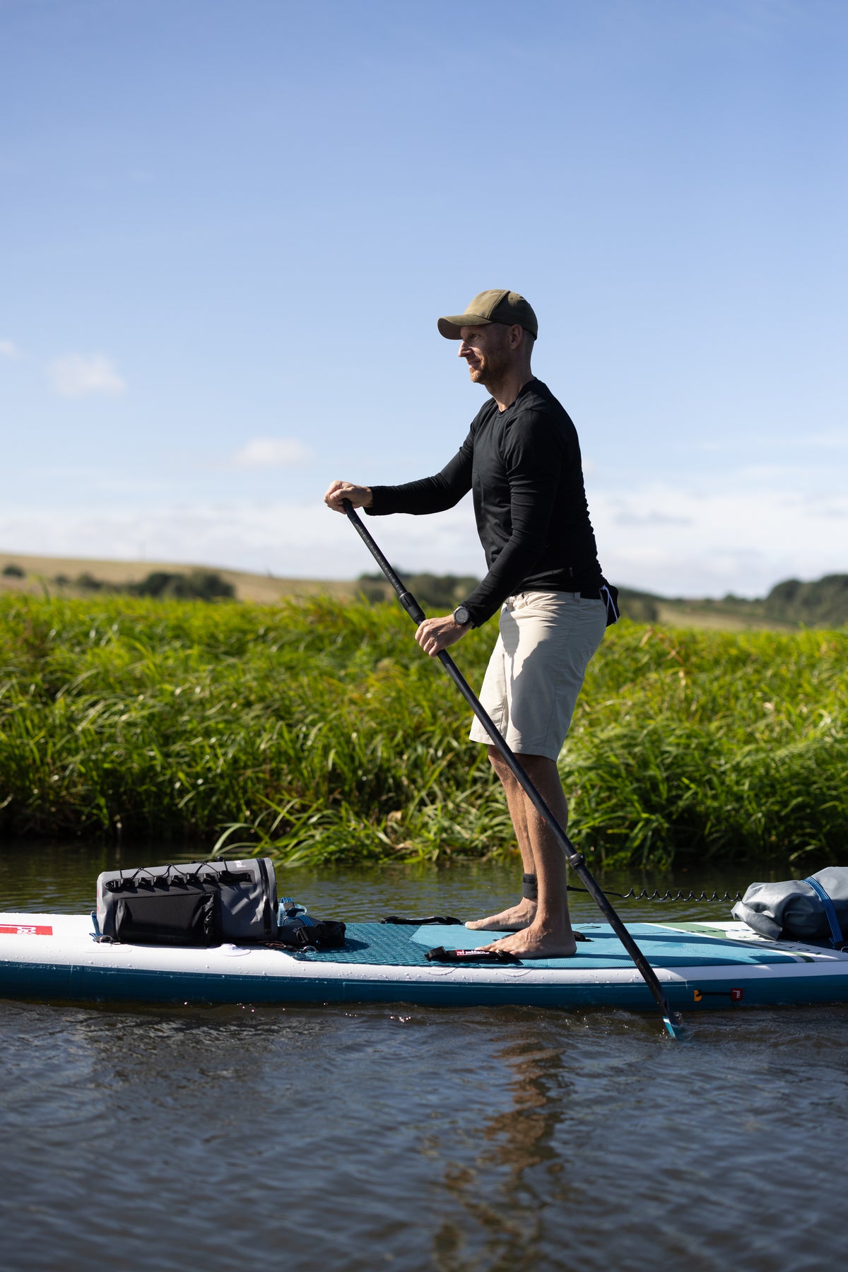 Anders Lorentzen paddling a SUP board in a black LOOW merino long sleeve